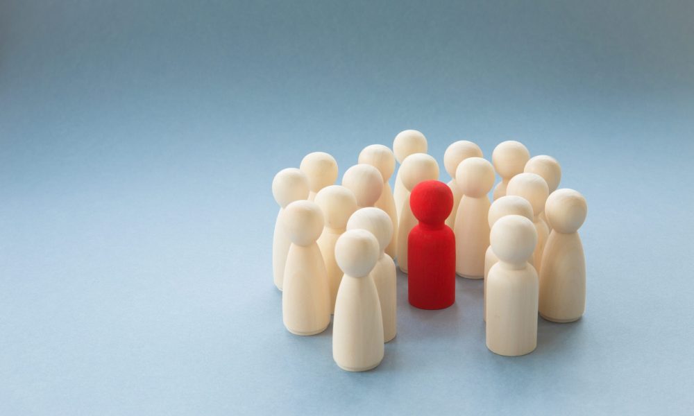 A socially diverse person being surrounded and protected by a crowd of people for being different.